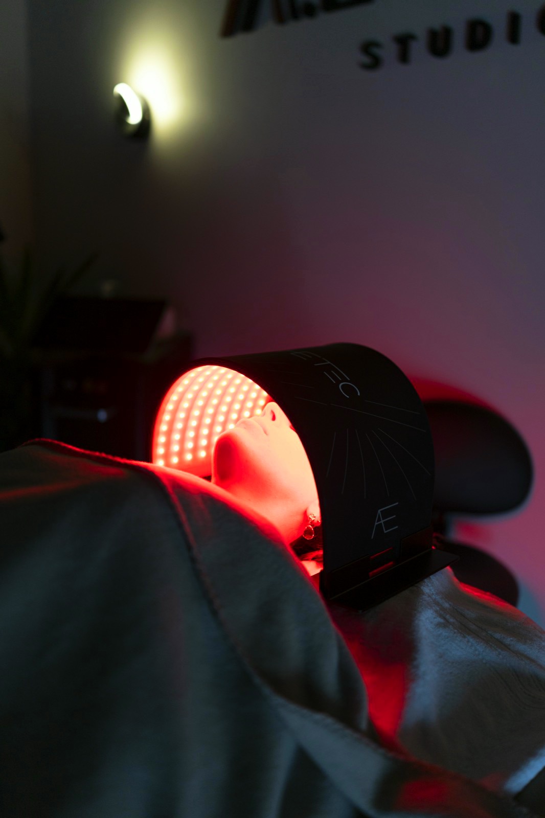 Séance de luminothérapie : masque LED rouge posé sur le visage d'une cliente