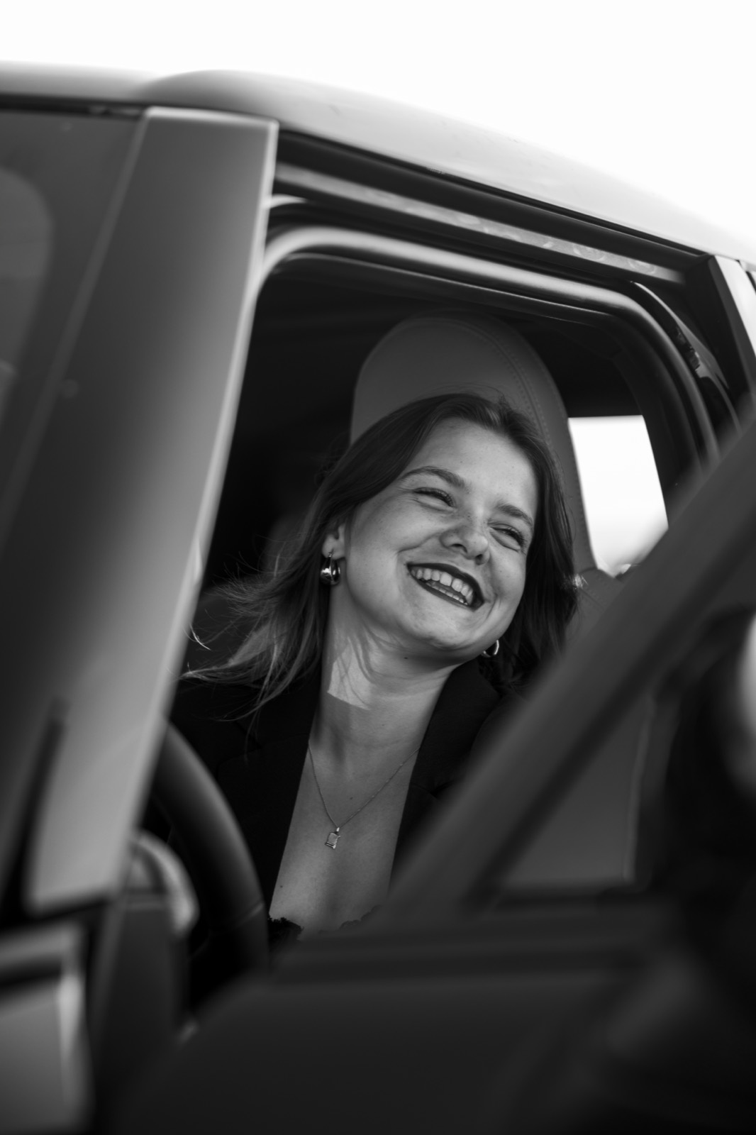 Portrait souriant en noir et blanc à la fenêtre de la MINI
