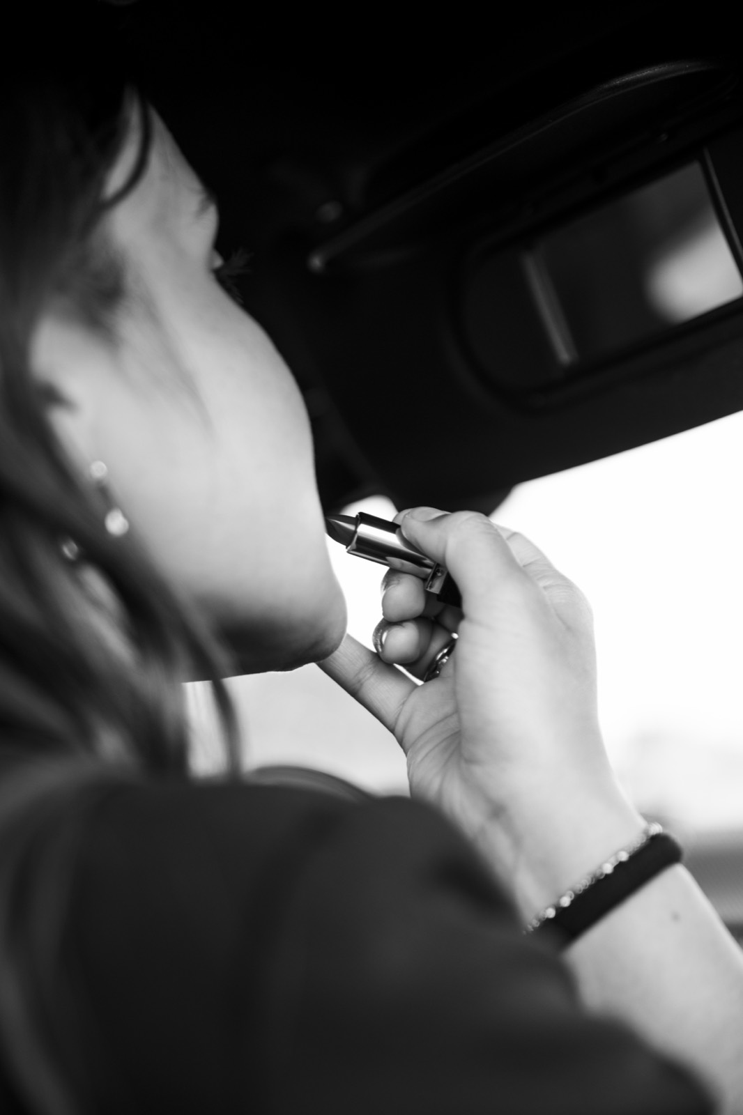 Détail en noir et blanc d'une femme se maquillant dans la MINI